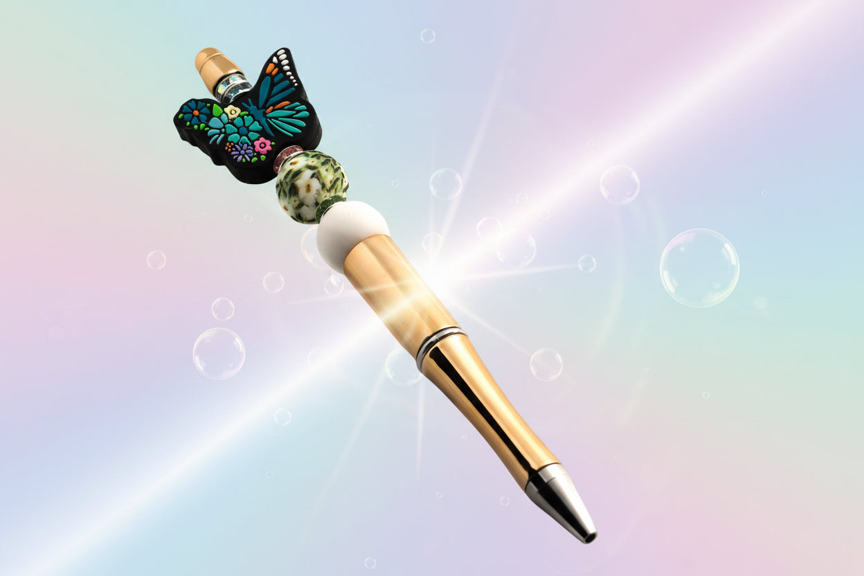 A decorative pen with a blue floral butterfly bead, daisy patterned bead, white bead and green, pink and blue glitter rondelles