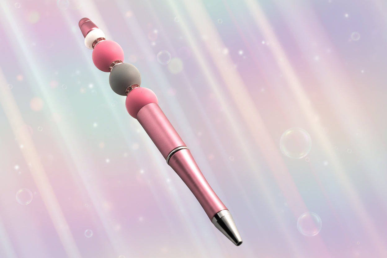 A pink metallic pen with 2 pink beads, a grey bead, a white oval bead and pink sparkly Rondelles.