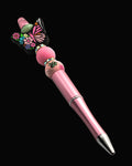 Pink pen with pink stacking silicon beads separated by glitter rondelles and a large butterfly silicon bead
