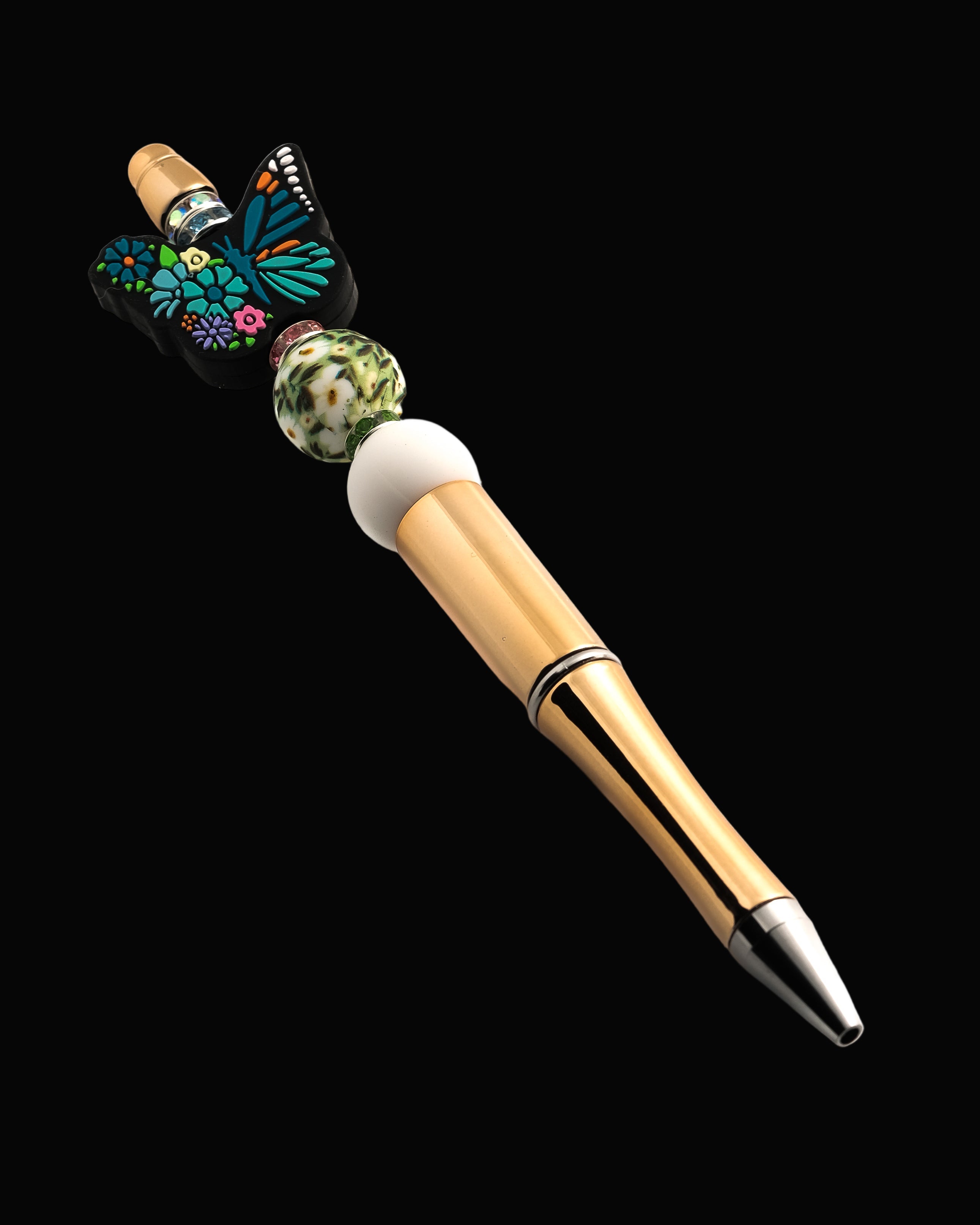 A decorative pen with a blue floral butterfly bead, daisy patterned bead, white bead and green, pink and blue glitter rondelles