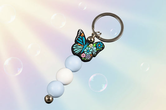 Multicoloured butterfly charm keychain with blue and white beads 