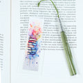Mark your place in style! This cheerful acrylic bookmark features a delightful design of books and flowers that celebrates the joy of reading.