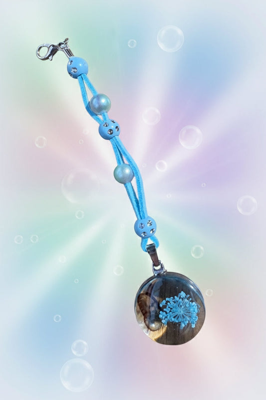 Add a touch of whimsy to your everyday carry with this beautiful handmade blue dangle charm. Each piece is lovingly crafted with sparkling blue beads and elegant white faux pearls, creating a delicate yet eye-catching accessory.
