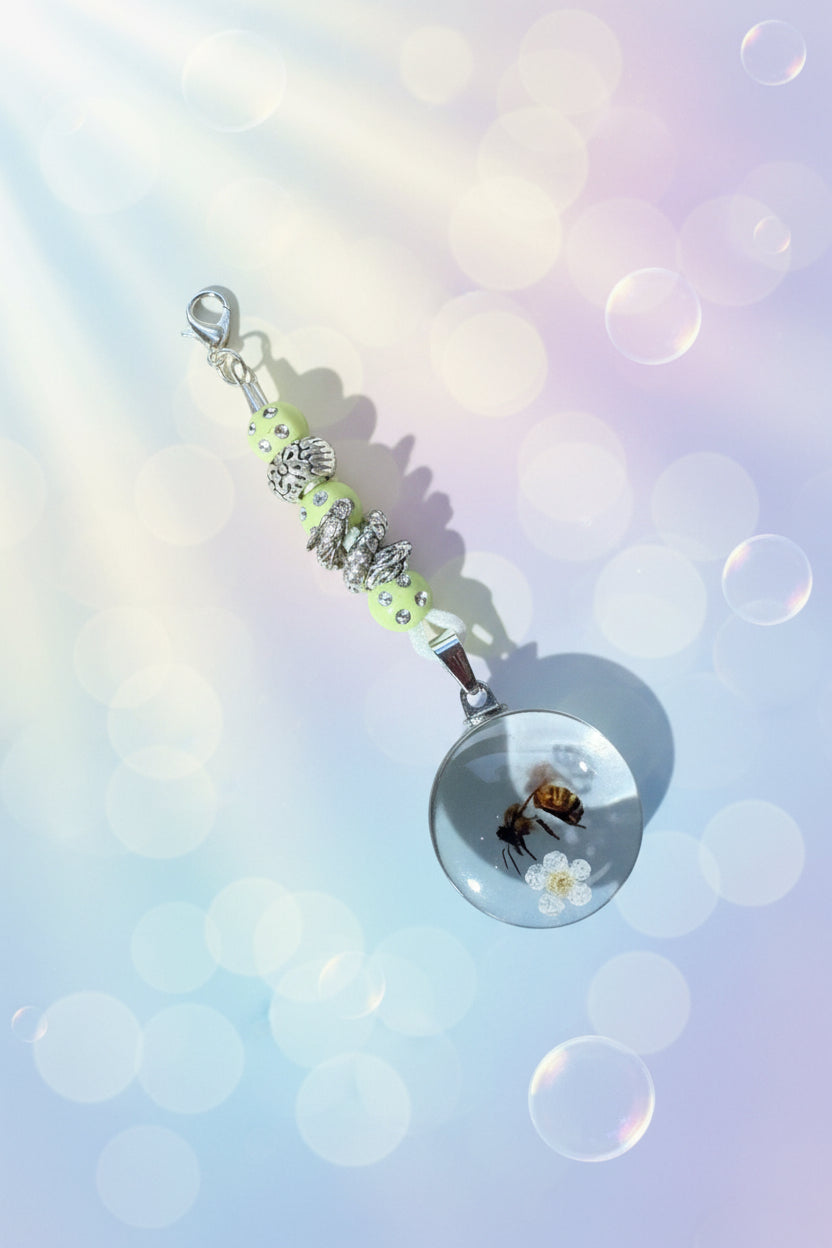 Add a touch of whimsy to your everyday carry with this beautiful handmade yellow dangle charm. Each piece is lovingly crafted with sparkling yellow beads and a cast floral bead with a curled dragon, creating a delicate yet eye-catching accessory.