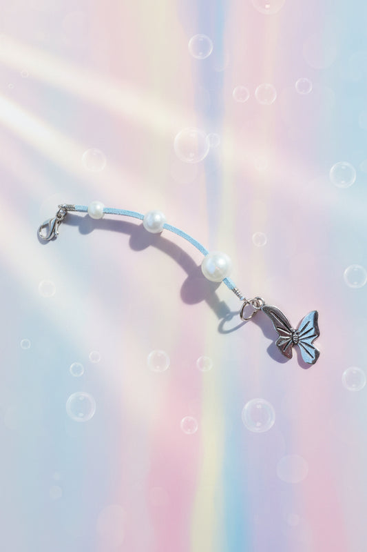 Add a touch of whimsy to your everyday carry with this beautiful handmade blue dangle charm. Each piece is lovingly crafted with sparkling blue beads and elegant white faux pearls, creating a delicate yet eye-catching accessory.