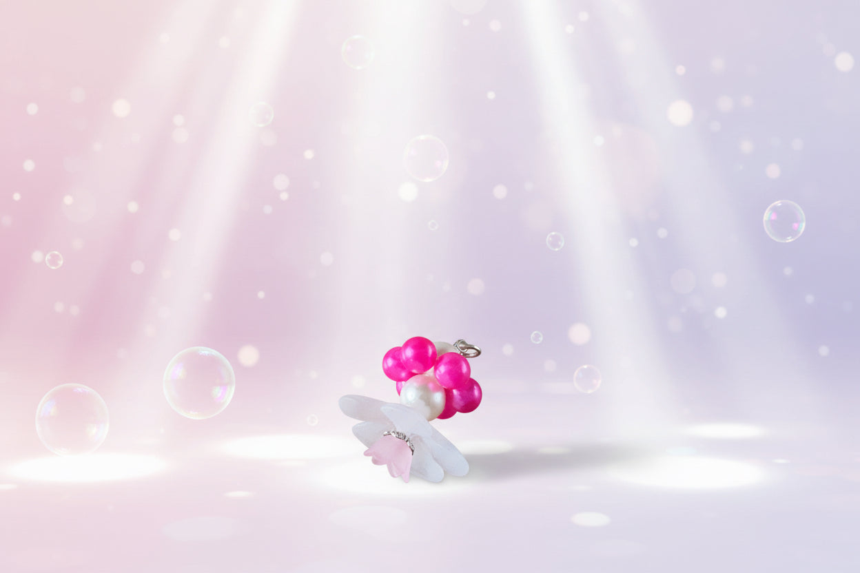 A stunning white flower bead takes centre stage, encircled by shimmering fuchsia pink pearlescent beads that create a mesmerising spinning effect. The soothing tactile motion helps with focus and stress relief while looking absolutely magical.