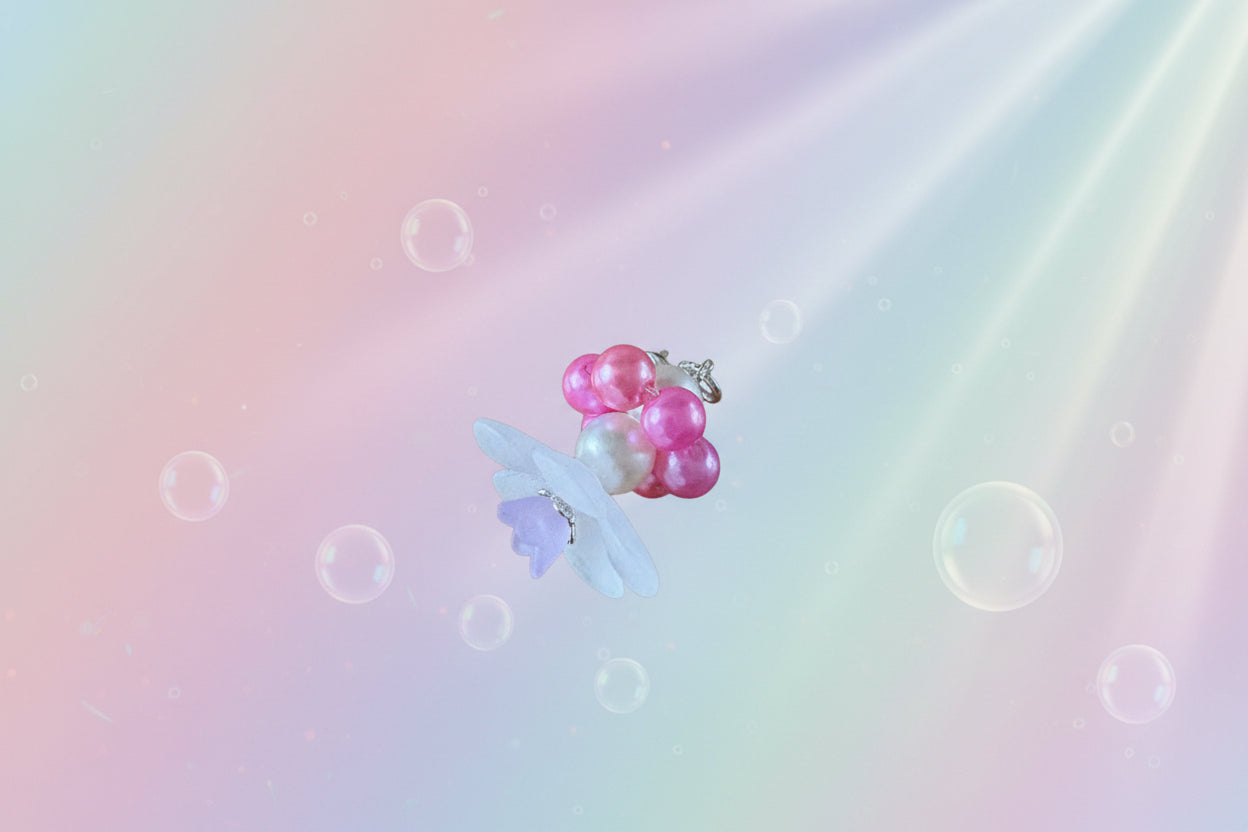 A stunning white flower bead takes centre stage, encircled by shimmering salmon pink pearlescent beads that create a mesmerising spinning effect. The soothing tactile motion helps with focus and stress relief while looking absolutely magical.