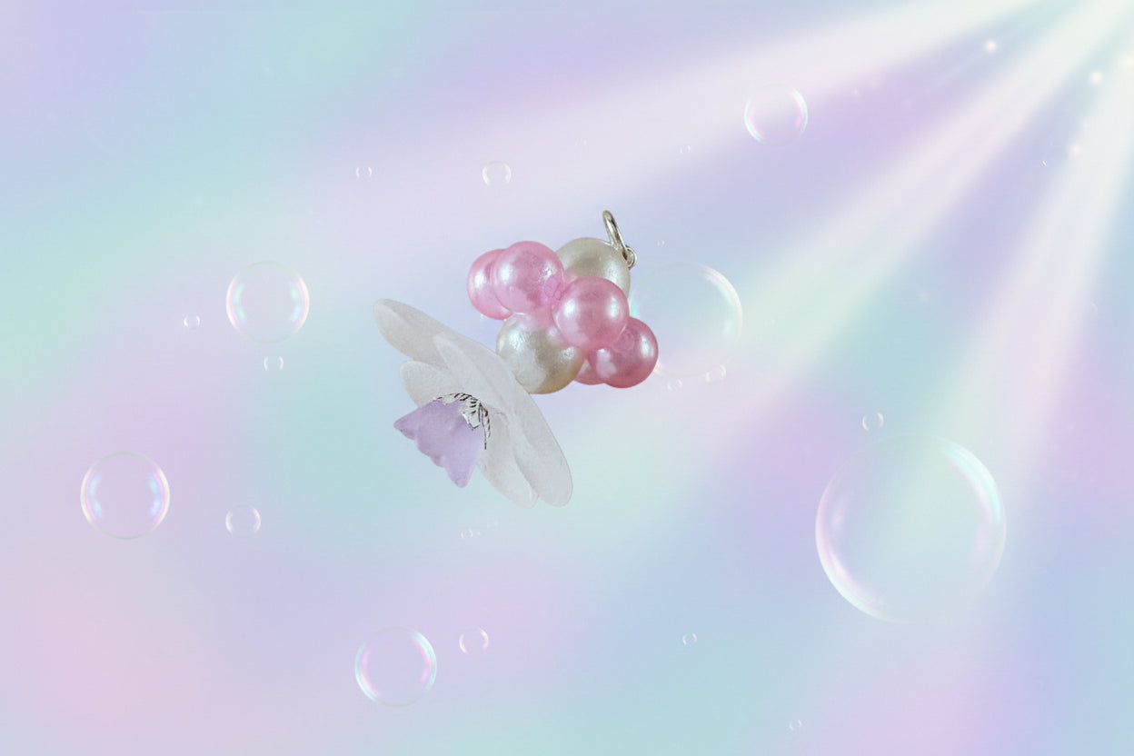 A stunning white flower bead takes centre stage, encircled by shimmering light mauve pearlescent beads that create a mesmerising spinning effect. The soothing tactile motion helps with focus and stress relief while looking absolutely magical.