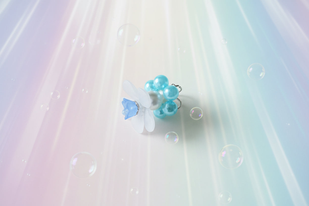 A stunning white flower bead takes centre stage, encircled by shimmering light blue pearlescent beads that create a mesmerising spinning effect. The soothing tactile motion helps with focus and stress relief while looking absolutely magical.