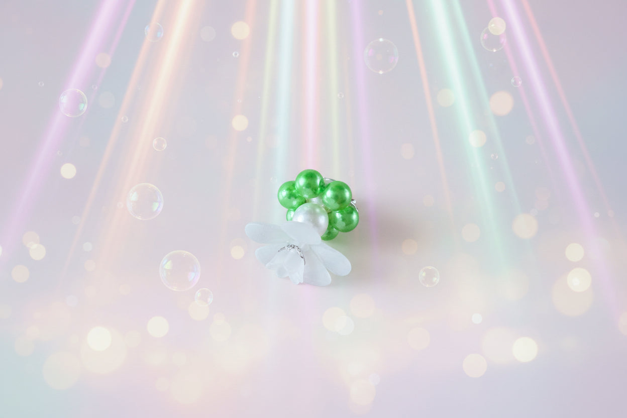 A stunning white flower bead takes centre stage, encircled by shimmering lime green pearlescent beads that create a mesmerising spinning effect. The soothing tactile motion helps with focus and stress relief while looking absolutely magical.