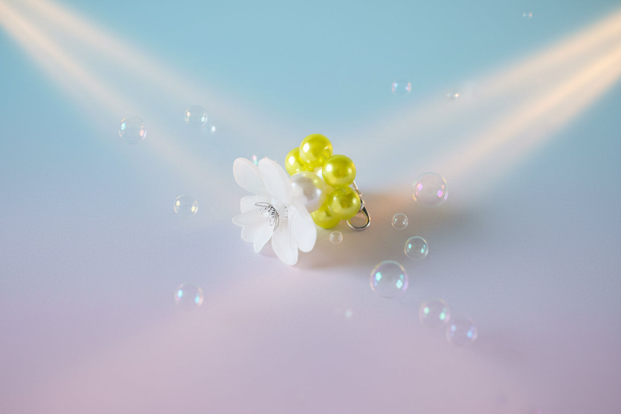 A stunning white flower bead takes centre stage, encircled by shimmering neon yellow pearlescent beads that create a mesmerising spinning effect. The soothing tactile motion helps with focus and stress relief while looking absolutely magical.