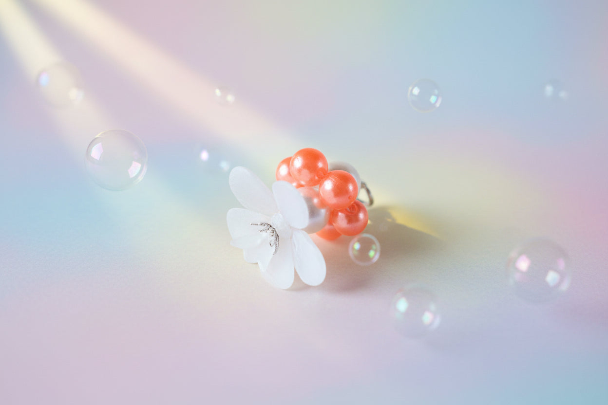 A stunning white flower bead takes centre stage, encircled by shimmering tangerine pearlescent beads that create a mesmerising spinning effect. The soothing tactile motion helps with focus and stress relief while looking absolutely magical.