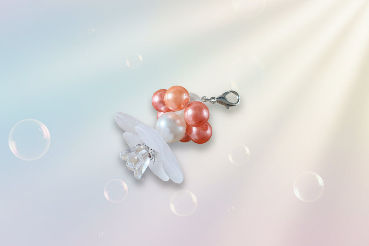 A stunning white flower bead takes centre stage, encircled by shimmering amber pearlescent beads that create a mesmerising spinning effect. The soothing tactile motion helps with focus and stress relief while looking absolutely magical.