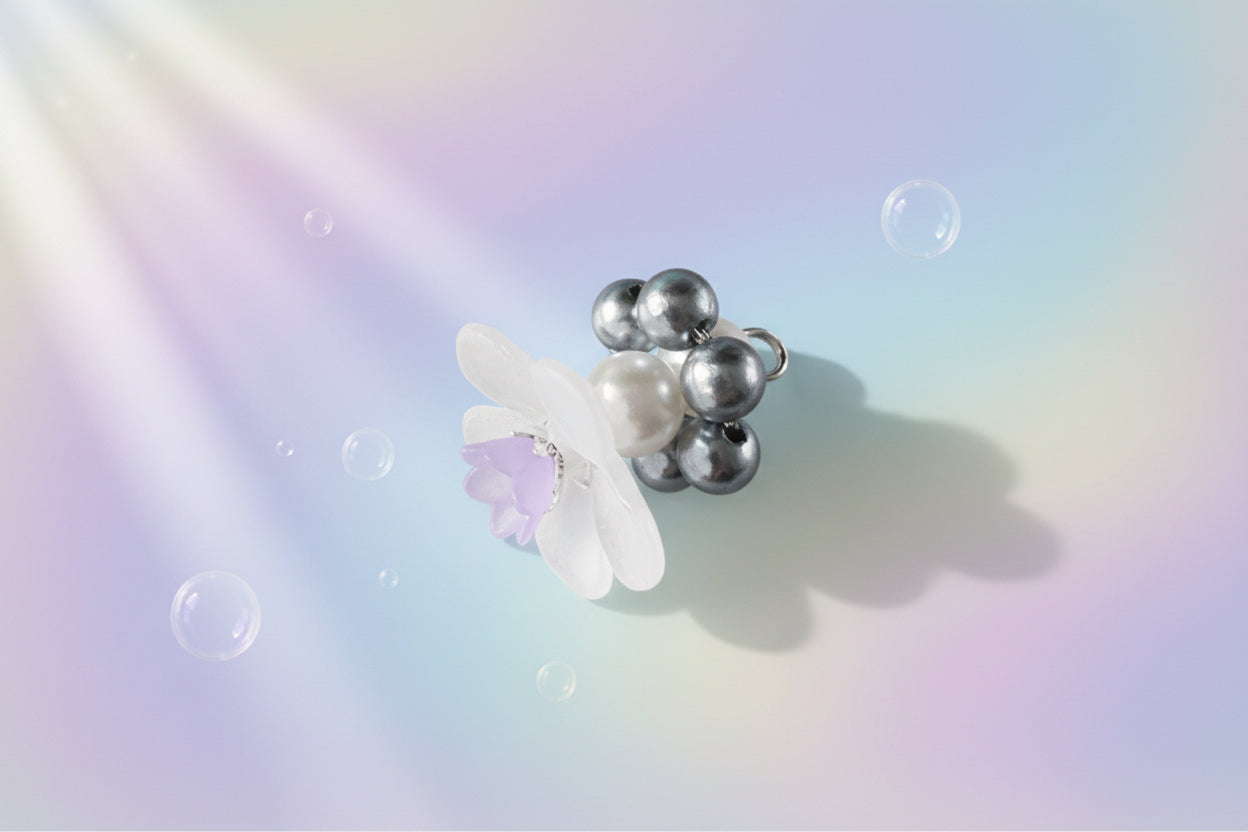 A stunning white flower bead takes centre stage, encircled by shimmering silver pearlescent beads that create a mesmerising spinning effect. The soothing tactile motion helps with focus and stress relief while looking absolutely magical.