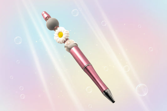A pink metallic pen with a white daisy shaped bead, a plain grey bead, a pink an grey floral bead with pink rondelles