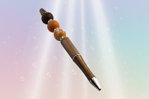 A bronze metallic pen with a brown bead, a terracotta bead, a floral bead, a fawn oval bead and sparkly Rondelles.