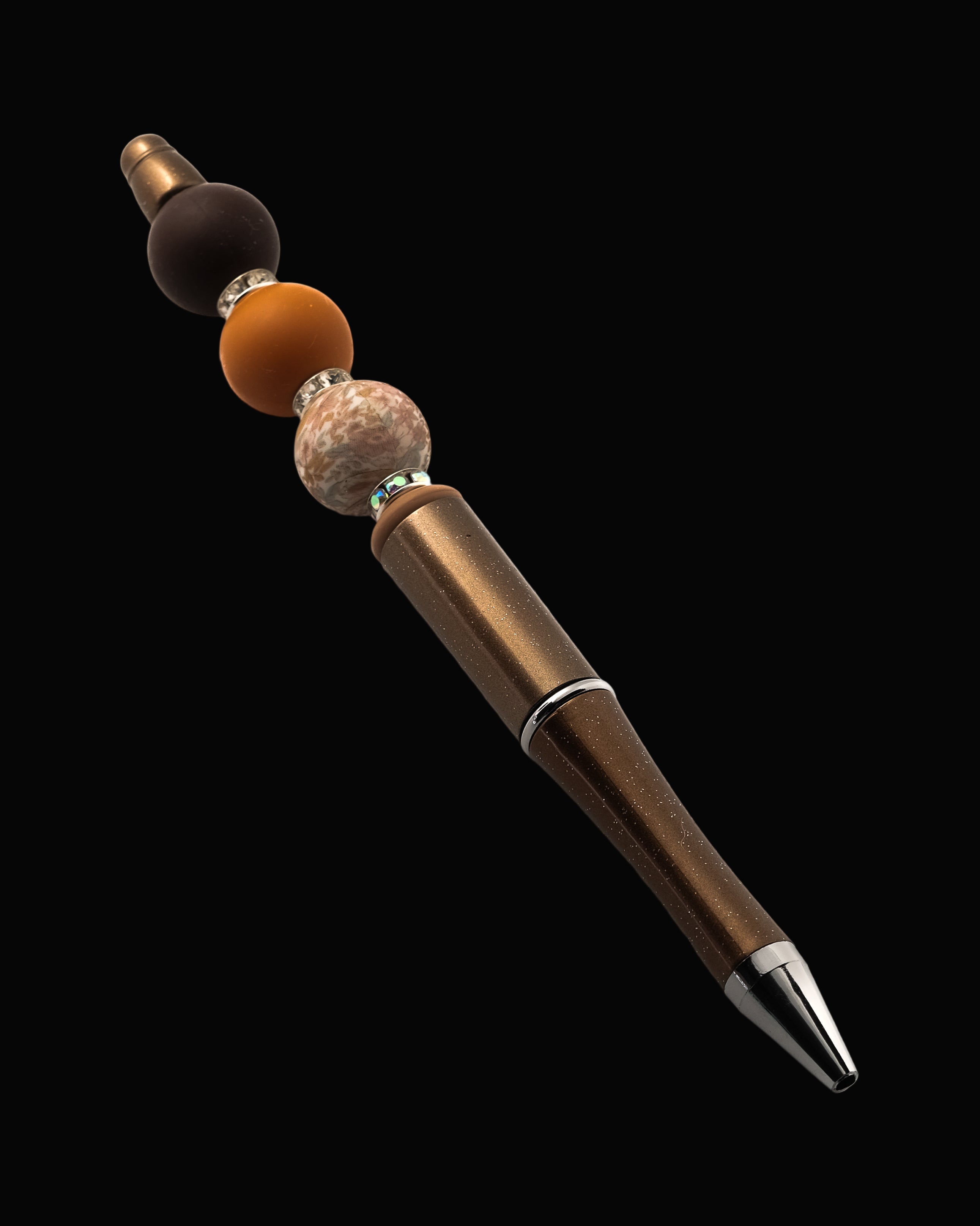 A chocolate brown metallic pen with a brown bead, a terracotta round bead, a floral bead, a fawn oval bead and sparkly Rondelles.