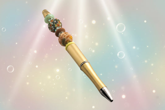 A gold metallic pen with floral beads, a yellow oval bead, a green oval bead, a fawn oval bead and sparkly Rondelles.