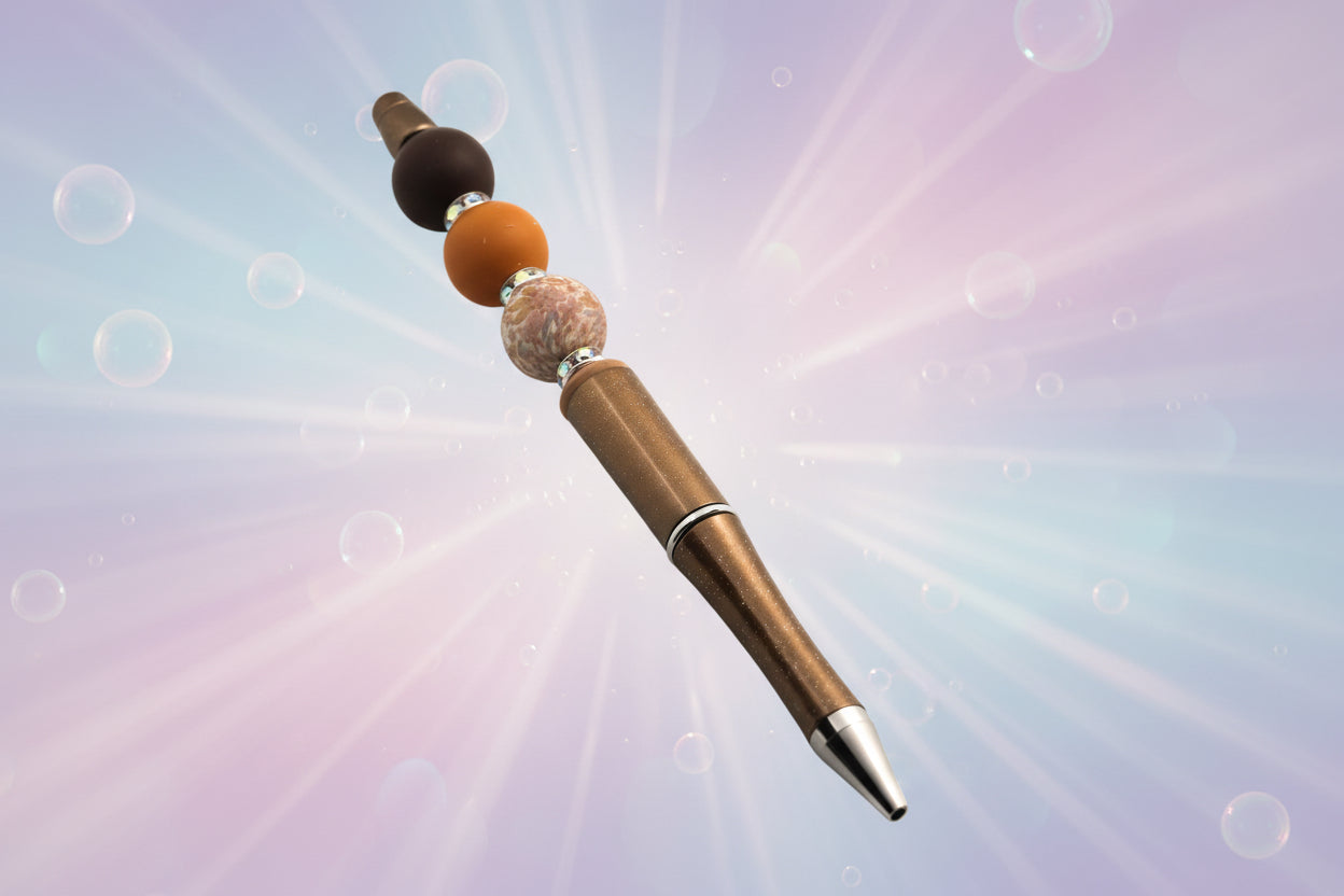A bronze metallic pen with a brown bead, a terracotta round bead, a floral beada fawn oval bead and sparkly Rondelles.