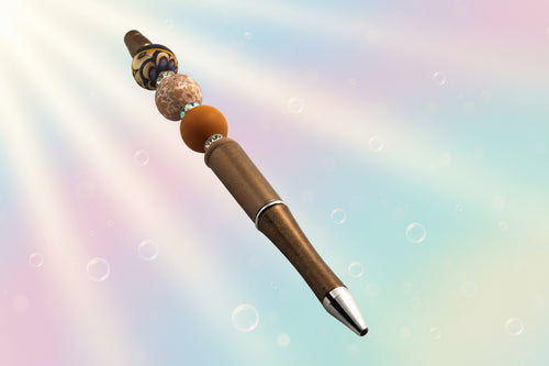 A bronze metallic pen with a terracotta bead, a floral round bead, an abstract bead, a fawn oval bead and sparkly Rondelles.