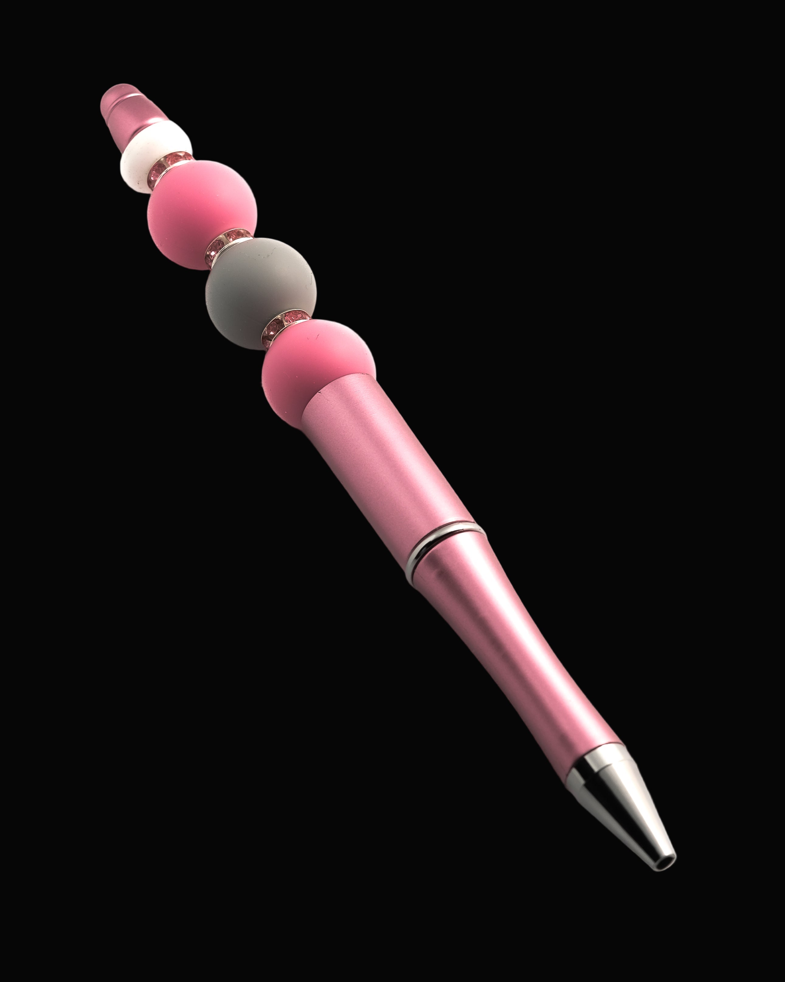 A pink metallic pen with 2 pink beads, a grey bead, a white oval bead and pink sparkly Rondelles.