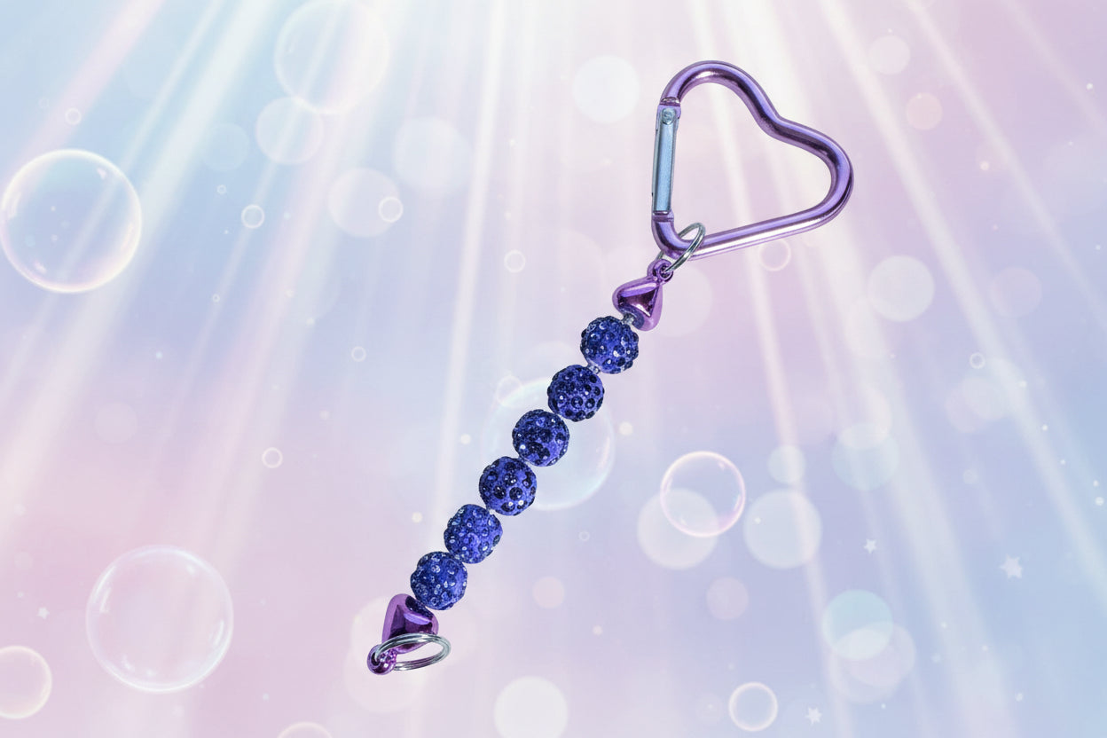 Add a touch of sparkle and love to your everyday essentials with this charming purple heart keychain. Adorned with shimmering beads, this delightful accessory brings personality and joy to your keys, bag, or backpack.
