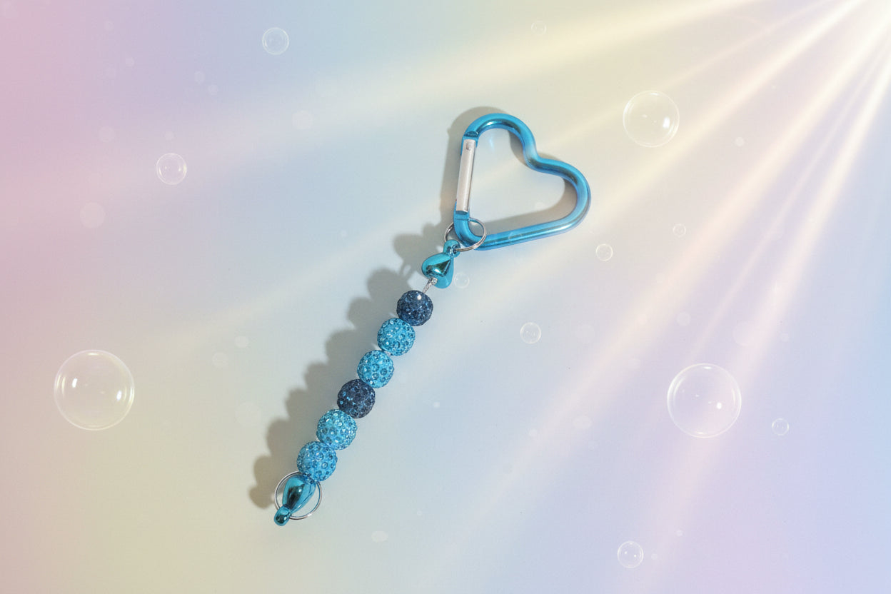 Add a touch of sparkle and love to your everyday essentials with this charming blue heart keychain. Adorned with shimmering beads, this delightful accessory brings personality and joy to your keys, bag, or backpack.