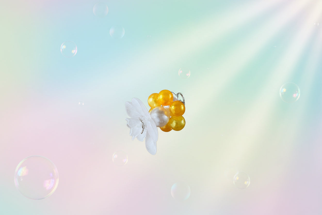 A stunning white flower bead takes centre stage, encircled by shimmering buttercup pearlescent beads that create a mesmerising spinning effect. The soothing tactile motion helps with focus and stress relief while looking absolutely magical.