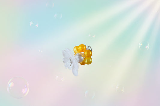 A stunning white flower bead takes centre stage, encircled by shimmering buttercup pearlescent beads that create a mesmerising spinning effect. The soothing tactile motion helps with focus and stress relief while looking absolutely magical.